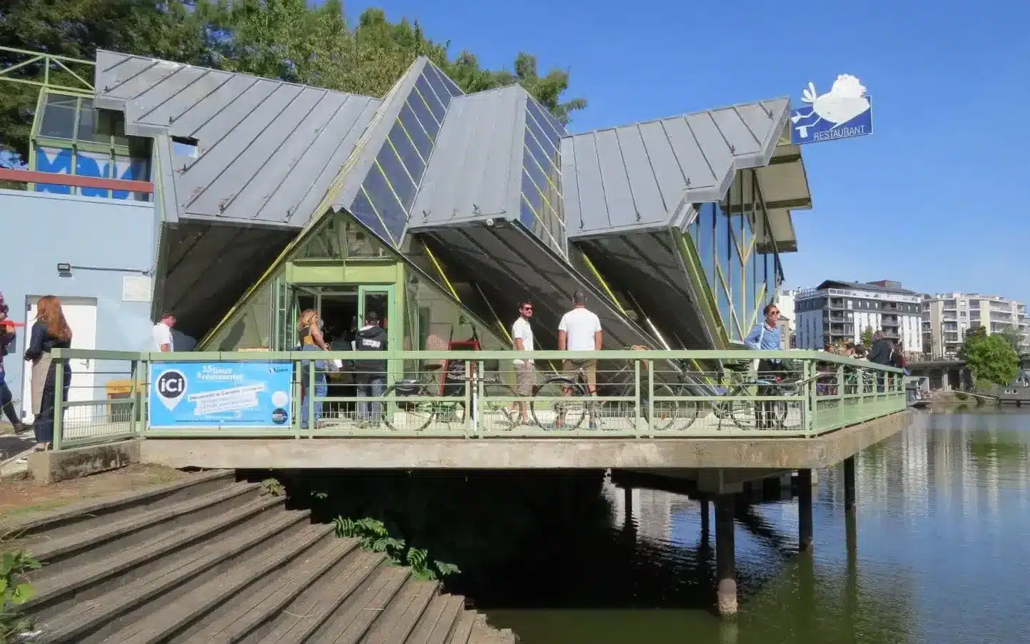 photo d'un bâtiment anguleux gris et vert au bord de l'eau