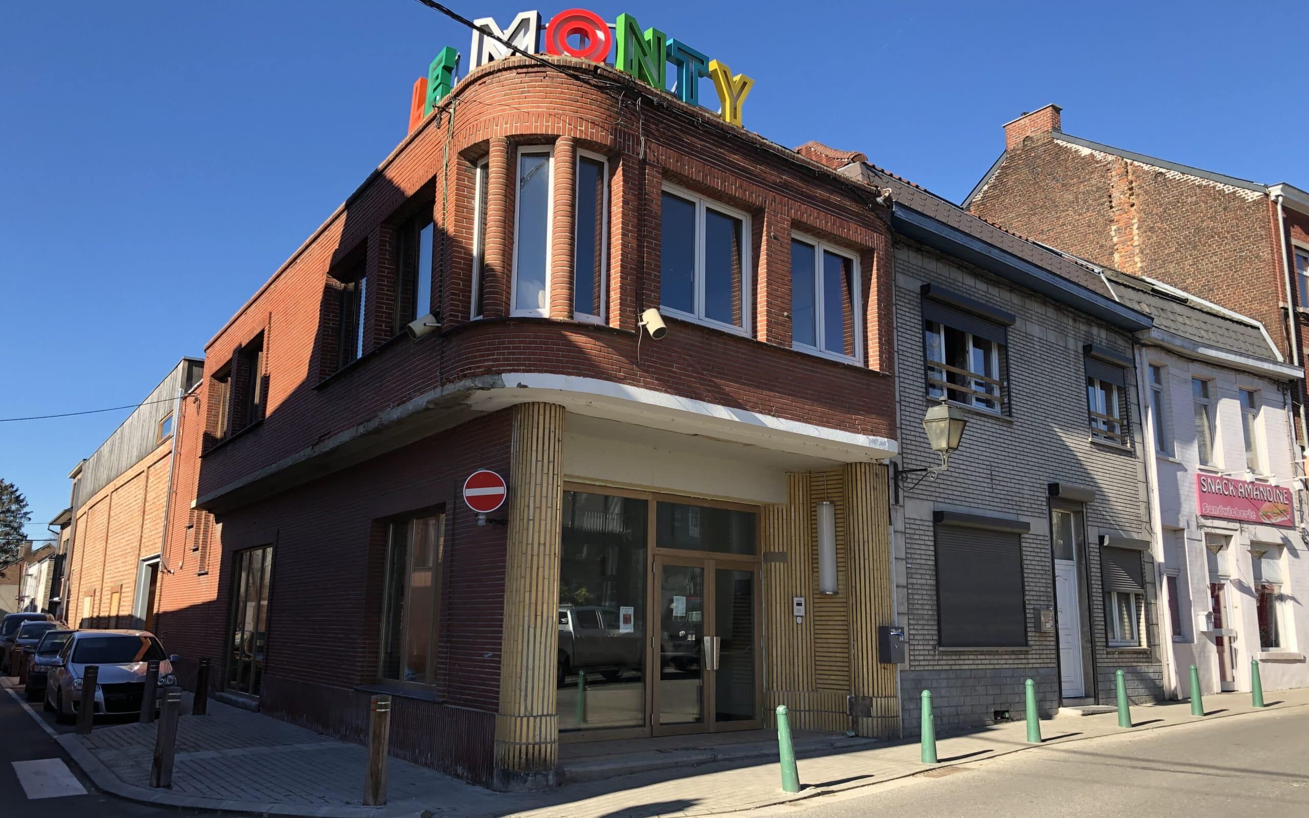 facade d'un batiment en briques avec écrit en gros "le monty" avec des lettres colorées